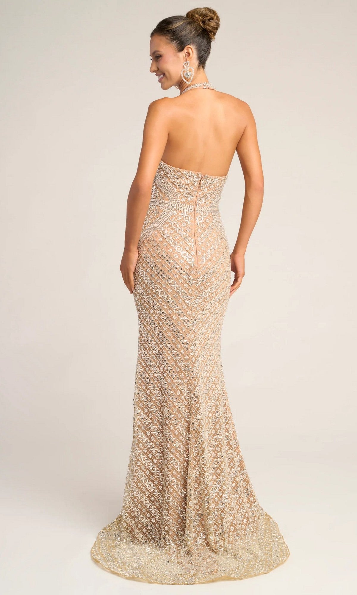 Woman in the Portia and Scarlett PS26425C, a strapless, floor-length gold sequin formal dress with a fitted silhouette, stands and looks over her shoulder against a plain background.